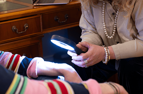Doctor looking for moles using a dermatoscope