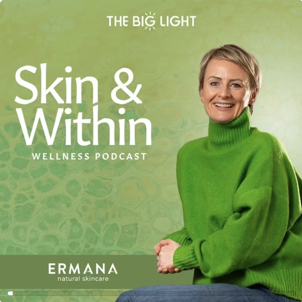 Claire Grey from Skin and Within sitting smiling in green jumper for her wellness podcast