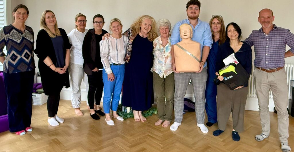 The Westbourne Team after CPR training standing in a line with a chest compression dummy.